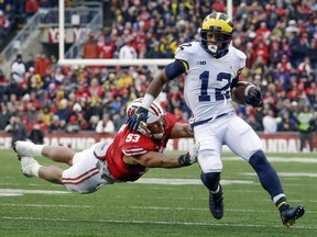 FILE - In this Nov. 18, 2017, file photo, Michigan's Chris Evans (12) runs past Wisconsin's T.J. Edwards, left, during the first half of an NCAA college football game in Madison, Wis. The unranked Wolverines need Evans to make all the right moves on the field at the Big House against No. 8 Ohio State. To pull off a big upset and spoil the Buckeyes' chances of playing for a national championship, Michigan might need Evans to have the kind of day Tshimanga Biakabutuka had in 1995 when he ran for 313 yards in one of the finest performances in the rivalry.