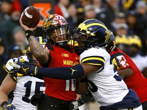 Michigan linebacker Josh Uche, right, tackles Maryland quarterback Ryan Brand as Brand throws an incomplete pass in the first half of an NCAA college football game in College Park, Md. Nov. 11, 2017.