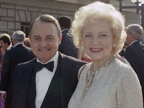 This Sept. 22, 1985, photo shows John Hillerman, left, and Betty White, right, arriving at Emmy Awards in Pasadena, Calif. A spokeswoman for the family of Hillerman says the co-star of TV's "Magnum, P.I." has died. Hillerman was 84. Spokeswoman Lori De Waal said Hillerman died Thursday at his home in Houston. She said the cause of death has yet to be determined.