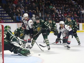 Windsor Spitfires forwards Chris Playfair and  Cole Purboo watch as London Knights goaltender Joseph Raaymakers makes a save during Sunday's  game at the WFCU Centre.