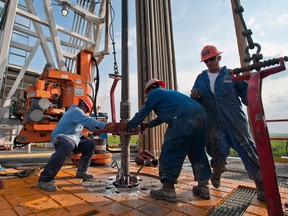 Local Input~ Floor hands Jose Garza, left, Jose Salinas, center, and Omar Cano make a pipe connection on Orion Drilling Co.'s Perseus drilling rig near Encinal in Webb County, Texas, U.S., on Monday, March 26, 2012. The Perseus is drilling for oil and gas in the Eagle Ford Shale, a sedimentary rock formation underlying an area of South and East Texas. Photographer: Eddie Seal/Bloomberg *** Local Caption *** Jose garza; Jose Salinas; Omar Cano