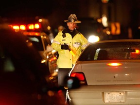 An OPP officer stops a vehicle at a check point on Riverside Drive in Tecumseh as part of a festive season R.I.D.E. campaign in this file photo.