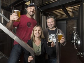 Co-owners of the Sandwich Brewing Co., Jason Sekala, left, Nicole Sekala and Scott Black raise a pint to celebrate the opening day of their establishment on Nov. 16, 2017.
