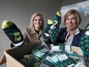 Kim Willis (left) and Claudia den Boer (right), director of communications and CEO of the Windsor-Essex County branch of the Canadian Mental Health Association, hold up Good Luck Socks of the fundraising Show Your Sole campaign on Nov. 6, 2017.
