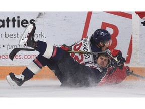 Kitchener Rangers forward  Kole Sherwood (92) is checked into the boards by Windsor Spitfires defenceman  Justin McEnemy (5) during Nov. 10, 2017, game at Memorial Auditorium Complex in Kitchener.