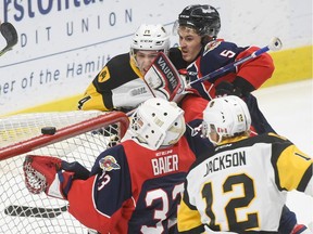 Windsor goaltender Brock Baier scrambles to grab a precariously perched loose puck as Hamilton's Zachary Jackson (12) swoops in while Windsor's Austin McEnery ties up Hamilton's Will Bitten during OHL action at FirstOntario Centre Sunday afternoon.