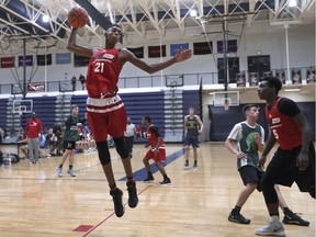 In this Oct. 8, 2017, photo, Emoni Bates pulls down a rebound against Howell High School during a fall league basketball game in Saline, Mich. The 13-year-old, six-foot-seven basketball player is one of the most coveted young players in hoops.