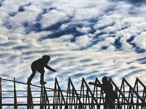 Construction workers complete framing on the roof of a business on Crawford Avenue in Windsor, Ontario on November 24, 2017.