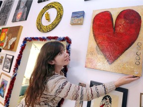 Artcite's Rory O'Connor adjusts a work of art by Michelle Chappus for the 36th annual Doin' the Louvre holiday art show and sale Saturday Dec. 2, 2017.  The sale runs through Dec. 24 with prices $199 and under.