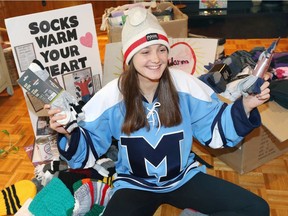 Sarah Lewis, 17, Grade 12 student at Vincent Massey secondary school, displays some of her socks and winter wear she is donating to area needy. Lewis is a member of the Massey hockey team which helped her, along with other campaigns, to raise $6,000 in her 10th year of fundraising.