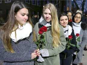 University of Windsor engineering students Mackenzie Noble, left, Robyn Marentette, Julia Costa and Amal Siddiqui, right, along with 10 other students and staff prepare to lay a rose Wednesday, Dec. 6, 2017, at the Memorial of Hope on campus.