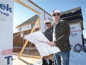 Mike McMahon, right, of Lakeland Homes, checks with home framer Shawn White on a home construction project on Westwood Drive in Lakeshore, Dec. 14, 2017.