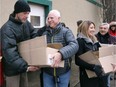 Canadian Italian Business and Professional Association members Frank Moceri, centre, and Sonia Lenhardt, right, deliver  Christmas food baskets at Goodfellows headquarters on Park Street West Saturday December 16, 2017.