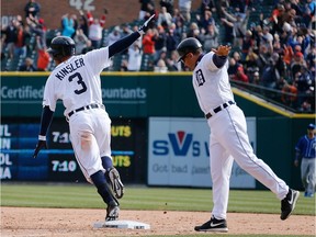 Ian Kinsler of the Detroit Tigers celebrates his 10th inning game winning RBI single with first base coach Omar Vizquel to beat the Kansas City Royals 2-1 at Comerica Park on April 2,  2014 in Detroit, Michigan.