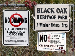 Signs are seen at the Black Oak Heritage Park near the Ojibway Shores woodlot in Windsor, Ontario on Oct. 24, 2017.