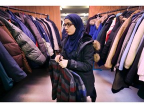 Sarah Bittar, 13, a student at the An-Noor private school hangs up some of the 400 coats that were donated to the Unemployed Help Centre in Windsor on Tuesday, December 19, 2017. The coats were collected by the An-Noor and Al-Hijra schools, the Rose City Islamic Centre and the Muslim Community of Windsor. Over the pass several years the groups have donated more than 4,000 coats to the program.