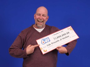Dale Brissette, 45, of Windsor, holds up his prize cheque for winning the Guaranteed $1 Million Prize Draw of Dec. 2, 2017.