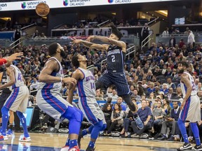 Orlando Magic guard Elfrid Payton (2) passes the ball over Detroit Pistons guard Ish Smith (14) and center Andre Drummond, front left, during the first half of an NBA basketball game in Orlando, Fla., Thursday, Dec. 28, 2017.