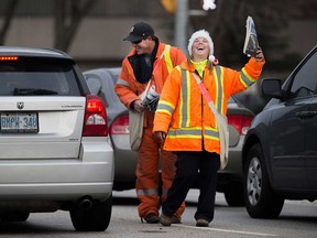 Windsor Goodfellows volunteers Alison Lodge (right)  and Rob Kolody (left) share a laugh while selling newspapers for the annual holiday season charity drive on Nov. 23, 2017.