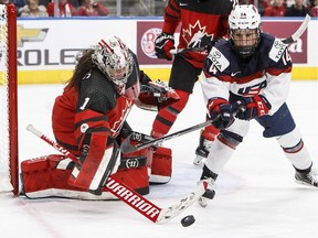 Team Canada goalie Shannon Szabados (1) makes a save on Team USA's Brianna Decker (14) during third period National Women's Team series hockey action in Edmonton, Alta., on Dec. 17, 2017.