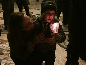 Anthony Zaiden, whose three-year-old brother Adam died from Sudden Unexpected Death Syndrome in 2015, attends a candlelight vigil Sunday night with family friend Rose Bacon. TREVOR WILHELM/Windsor Star