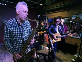 Kelly Hoppe plays saxophone while Jody Raffoul looks on as The S'Aints perform at the Windsor Star's News Cafe on Dec. 8, 2017.