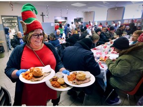The Downtown Mission served a special Christmas meal on Thursday, Dec. 14, 2017 to members of the community who are struggling with poverty and homelessness. Volunteer server Laurie Musson delivers plates to guests during the meal.