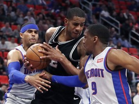 San Antonio Spurs forward LaMarcus Aldridge (12) pulls down a rebound between Detroit Pistons forward Tobias Harris, left, and guard Langston Galloway (9) during the first half of an NBA basketball game, Saturday, Dec. 30, 2017, in Detroit.