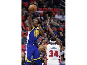 Golden State Warriors forward Kevin Durant (35) passes the ball over Detroit Pistons forward Tobias Harris (34) during the first quarter of an NBA basketball game Friday, Dec. 8, 2017, in Detroit.