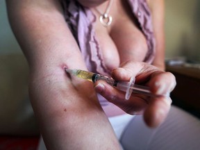 A Windsor drug addict who relies on prostitution to feed her habit injects herself with dilaudid in this file photo.