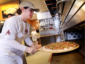 Marena Loqa an employee at Antonino's Original Pizza Inc. makes a pie on Dec. 27, 2017, at the South Windsor location.