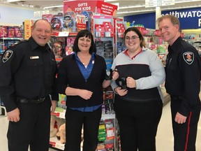 Windsor Police Sgt. Steven Betteridge, left, and Const. Andrew Drouillard, pose with two unidentified employees of Shoppers Drug Mart, who helped prevent a fraud.