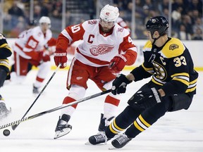 Boston Bruins' Zdeno Chara (33), of Slovakia, battles Detroit Red Wings' Henrik Zetterberg (40), of Sweden, for the puck during the first period of an NHL hockey game in Boston, Saturday, Dec. 23, 2017. (AP Photo/Michael Dwyer)