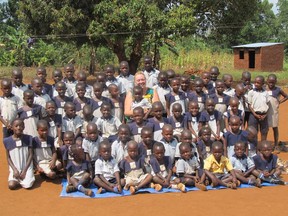Retired Essex County teacher Geri Sutts, founder of the Canadian chapter of Save African Children Uganda (SACU), sits with chidlren in the village of Buwundo, Uganda.