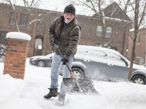 Harry Hiemstra tries to stay ahead of the snowfall as he clears his sidewalk outside him home on Monmouth Rd., Wednesday, Dec. 13, 2017.