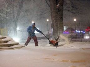 A man with a snow blower tries to keep up with the weather at Ste. Anne Parish in Tecumseh on Dec. 13, 2017.