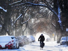 A cyclist navigates a snow-covered roadway on McEwan Avenue in Windsor on Dec. 12, 2017.