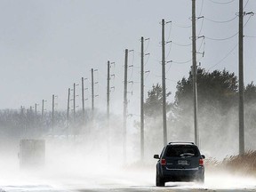 A vehicle makes its way through snow on County Road 42 in Lakeshore in this 2017 file photo.