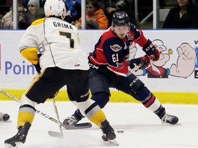 Windsor Spitfires' Luke Boka (61) protects the puck from Sarnia Sting's Nick Grima (7) in the second period at Progressive Auto Sales Arena in Sarnia on Thursday, (Mark Malone/Chatham Daily News/Postmedia Network)