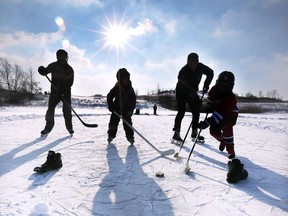 Bradley Nichols, left, Claire Dunnell, 7, Mike Dunnell and McKinley Nichols, 7, play shinny at the Blue Heron pond in Windsor on a crisp winter day Dec. 29, 2017.