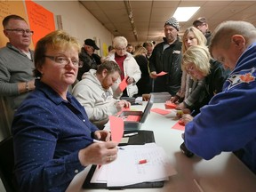 Lakeshore, Ontario. January 6, 2018. Hundreds of current, past and future members at Stoney Point Sportsmen's Club line up to pay membership dues and make donations to Karen Nelms, seated left, and Andrew MacLean, following a well-attended meeting to discuss the financial woes of the popular club on Lake St. Clair January 6, 2018.