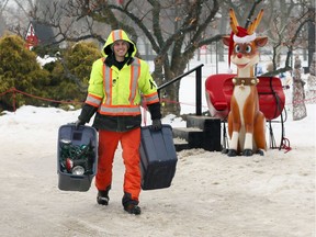 Elctrician Matt Deschamps of Tucker Electric carries spot lights as crews disassemble thousands of feet of electrical lights and extension cords at Bright Lights Windsor on Jan. 10, 2018. The main Christmas tree in the centre of Jackson Park will remain until the weather is suitable for a large crane to be brought in to remove the steel framework.