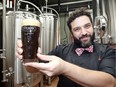 Adriano Ciotoli holds a glass of Chocolate Porter at Frank Brewing Co. on Jan. 14, 2018. Chocolate Porter is one of featured items on Frank's Winter Bites menu.
