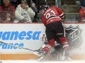 The Windsor Spitfires' Louka Henault is driven in to the boards by the Guelph Storm's James McEwan Friday, No penalty was called on the play and Henault did not return to the game as the Spitfires lost 3-1 to the Storm at the Sleeman Centre. Tony Saxon/GuelphToday - for Windsor Star