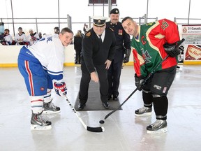 Hockey players Lieut. Ed Beaune, left, and Capt. Brad Krewench, right, participate in the ceremonial face-off by Lt-Cmdr. Robert Head and Master Corp. Brian Eagle, behind, at the first Annual Windsor Military Hockey Day in Canada held at Lanspeary Park Saturday Jan. 20, 2018.