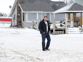 Foster Avenue property owner Mike McQueen walks over a disputed portion of land which is located directly behind his homes and a paved walkway which leads to the Leamington waterfront promenade on Tuesday Jan. 30, 2018.