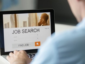A man searches for a job online in this photo illustration.