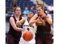 The Windsor Lancers Kayah Clarke, centre, gets sandwiched by Clare Sharkey, left, and Linnaea Harper of McMaster during Wednesday's game at the St. Denis Centre.