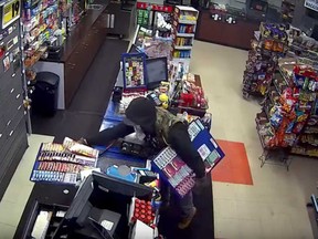 A break-in thief takes racks of scratch tickets in this image from a security camera at a convenience store in the 200 block of Strabane Avenue in Windsor on Dec. 27, 2017.