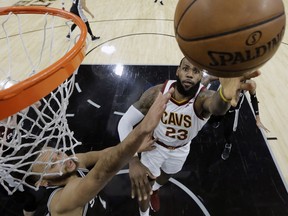 Cleveland Cavaliers forward LeBron James (23) shoots past San Antonio Spurs forward Kyle Anderson (1) during the first half of an NBA basketball game, Jan. 23, 2018, in San Antonio. James passed the 30,000 career points mark in the first quarter.